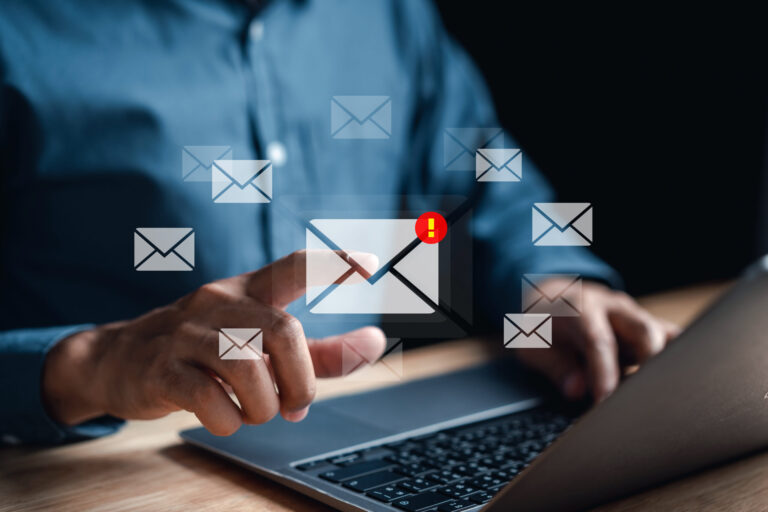 Laptop with a cluttered inbox and floating emails, one marked urgent — symbolizing ADHD email overwhelm and distraction