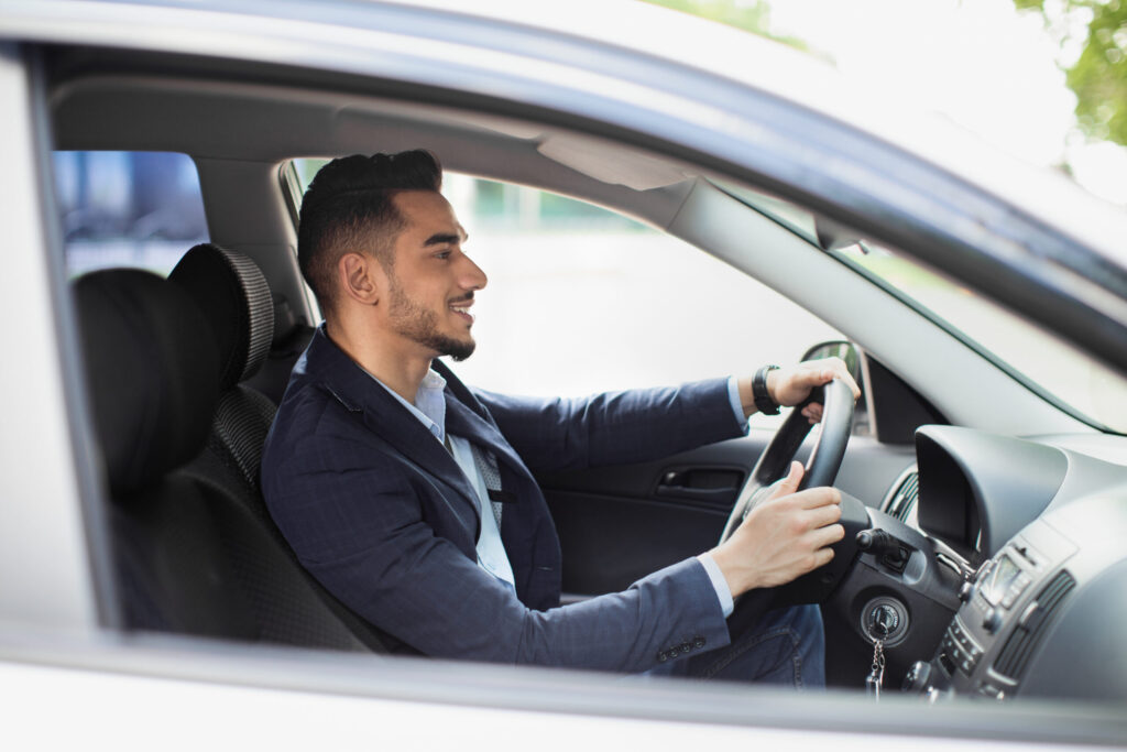 Adult man driving his car to work on time, demonstrating punctual morning routine