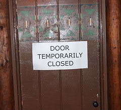 Wooden door with a paper sign reading “Door temporarily closed,” illustrating interruptions faced by adults with ADHD