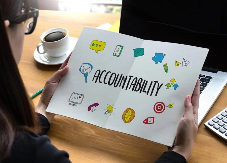 Women holding paper that says accountability to show how adhd adults can form accountability partnerships.
