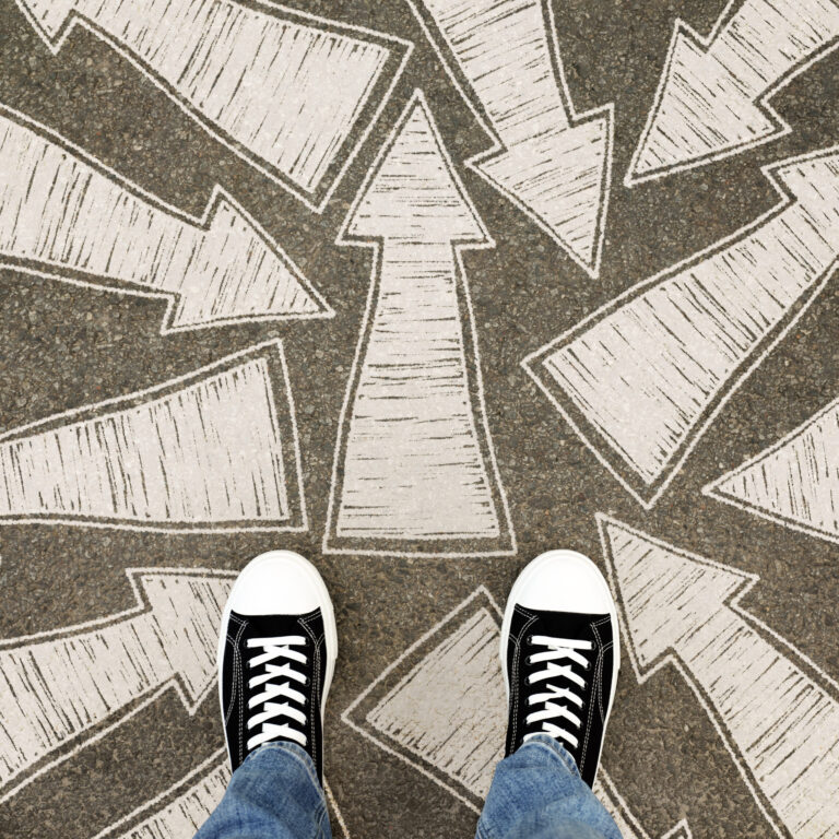 Person standing at multiple arrows on the ground, symbolizing ADHD overcommitting and difficulty deciding what to take on