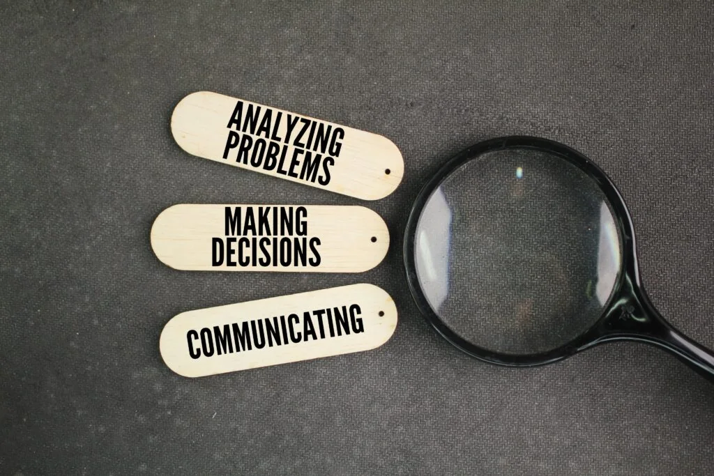 Magnifying glass next to labels reading "Analyzing Problems," "Making Decisions," and "Communicating," representing executive functioning skills in adults with ADHD.