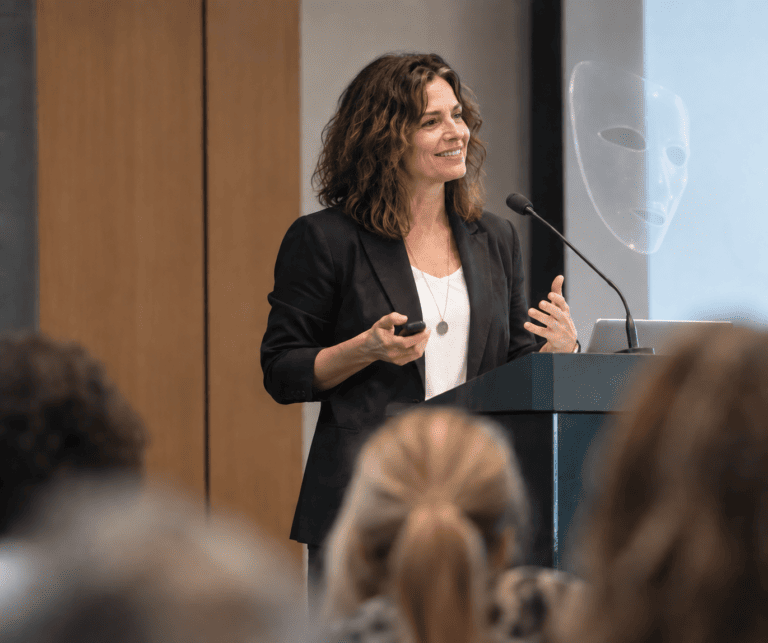 Woman speaking at a conference illustrating ADHD masking and how adults with ADHD may hide their symptoms